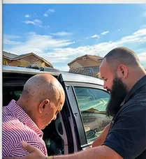 Chofer ayudando a un pasajero a subir a la minivan